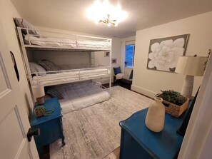 A bunk bed room with a desk, a lamp, and a window with a view. - Beautiful, spacious country home in Cache Valley with views (Wellsville)