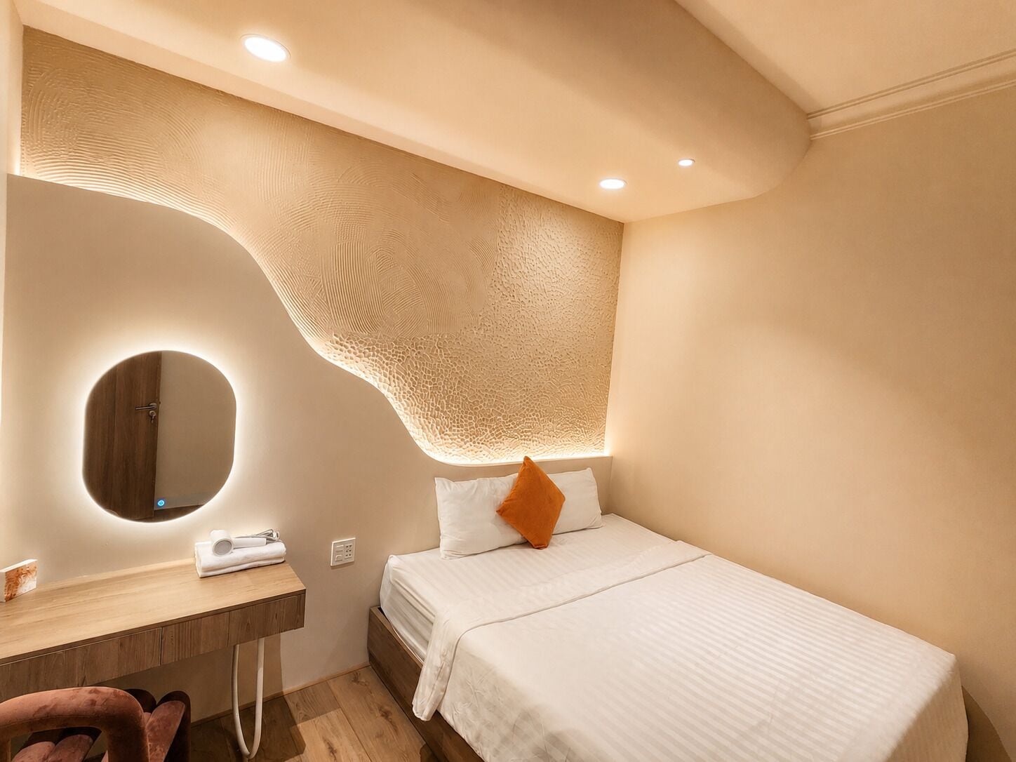 Ein Schlafzimmer mit einem Bett, einem Schminktisch mit Spiegel und einem Holztisch.