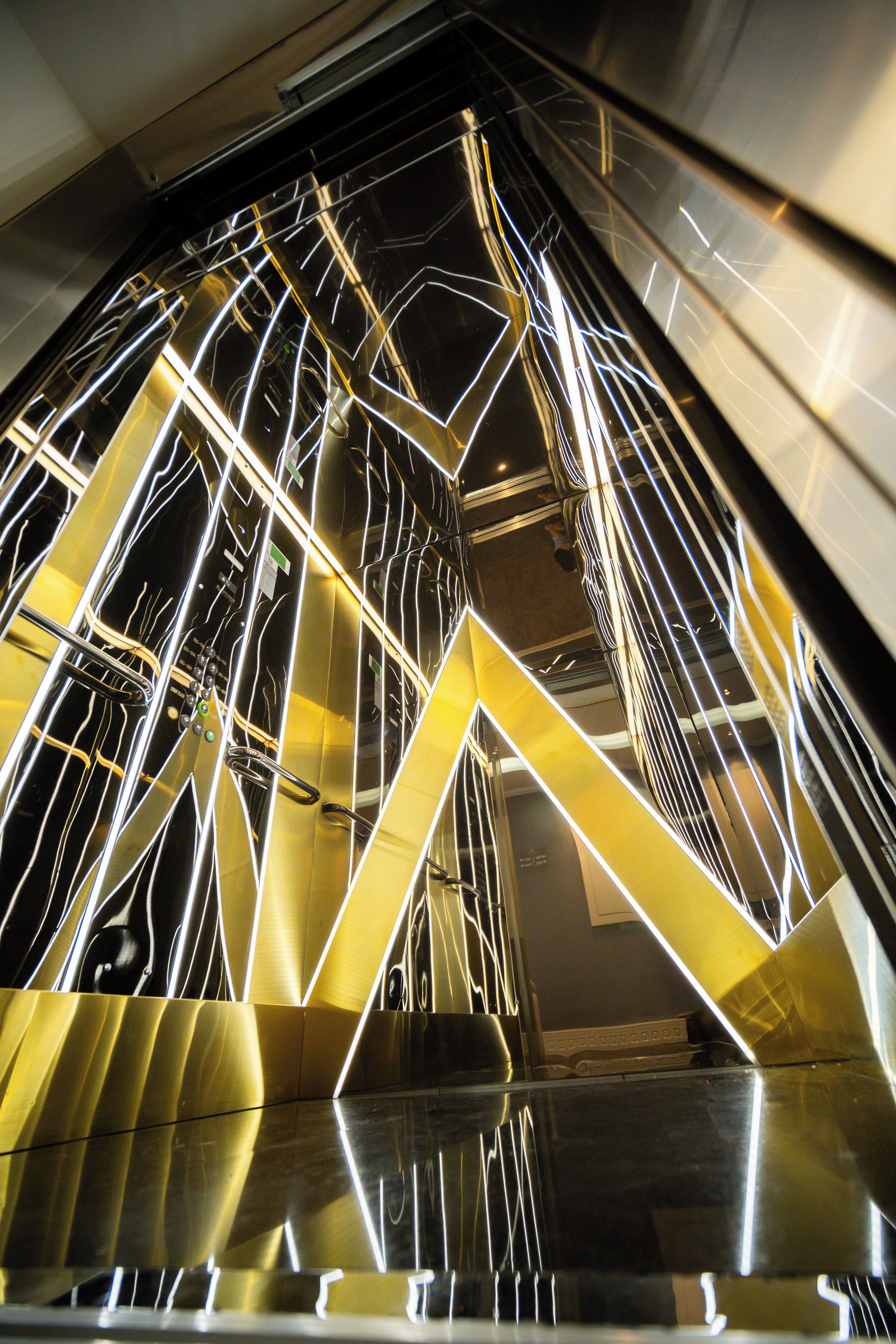 Un intérieur moderne avec des structures métalliques aux formes géométriques et des surfaces réfléchissantes.
