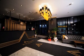 A modern hotel lobby with a reception desk, seating area, and a chandelier. - Alion Hotel Izmir (Izmir)