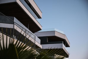 A modern multi-story building with balconies and a clear sky.