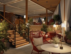 A modern interior with a staircase, seating area, and potted plants.