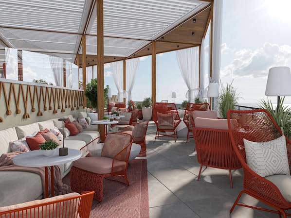 A rooftop terrace with outdoor seating, a dining area, and a view of the sea.