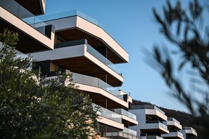 A multi-story building with balconies and a clear sky.