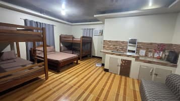 Una habitación con literas, kitchenette y piso estampado.