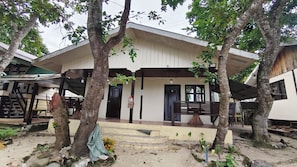 A building with a covered porch, a fire extinguisher, and a number 16 door.