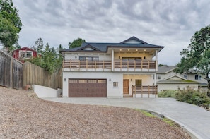 A two-story house with a garage, a balcony, and a driveway.