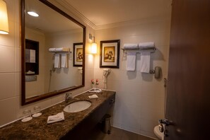 A bathroom with a marble sink, a large mirror, two framed pictures on the wall, and a towel rack. - Saja by Warwick, Makkah (Makkah)