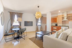 A compact living space with a dining area, a sofa, a TV, and a kitchenette. - Apt Blueseas Bahia Marina (El Puerto de Santa Maria)