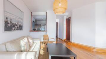 Una sala de estar moderna con un sofá, una mesa de centro y una lámpara colgante.
