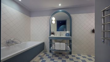Une salle de bain avec une baignoire, un meuble-lavabo avec un miroir et un porte-serviettes.