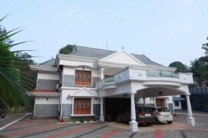 A two-story house with a balcony, a garage, and a driveway.