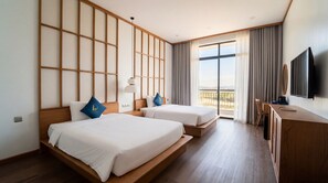 Ein Hotelzimmer mit zwei Betten, einem Fernseher und einem Balkon mit Blick.