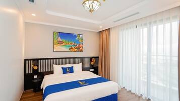A hotel room with a bed, a painting, a nightstand, and a window with curtains.