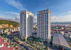 A high-rise hotel with multiple floors, a prominent sign at the top, and a view of the surrounding urban landscape.