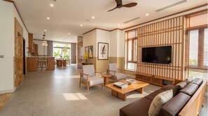 A modern living room with a sofa, chairs, a coffee table, and a TV. - D'lioro Hotel And Resort (Ha Long)