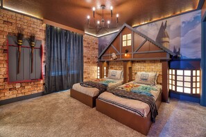 A bedroom with a brick wall, a ceiling with exposed beams, a bed with a Hogwarts-themed duvet, and a window with a view of a castle. - Breezy Palms|Spectacular NEW Villa|NEW WOW Resort (Clermont)
