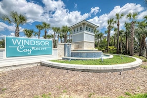 Schild für das Windsor Cay Resort mit einem Steinhaus und einem Brunnen im Vordergrund.