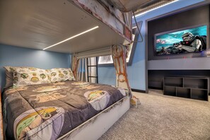A bedroom with a bunk bed, Star Wars-themed bedding, a television on the wall, and a rustic ceiling. - Breezy Palms|Spectacular NEW Villa|NEW WOW Resort (Clermont)