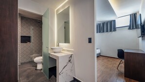 A modern bathroom with a marble sink, a toilet, and a shower area. - Hotel Mexico (Mérida)