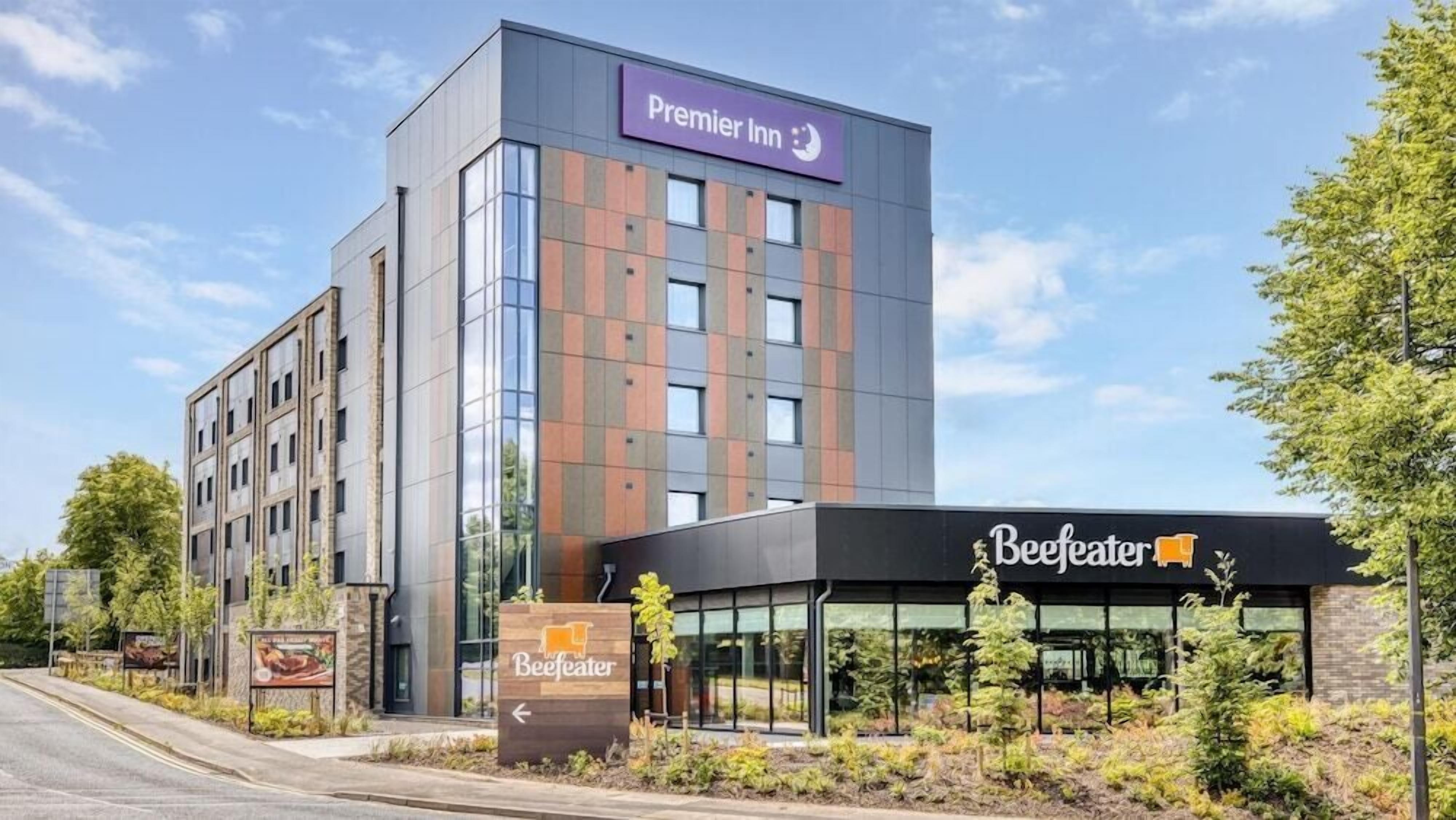 A hotel with a modern design, featuring a prominent Premier Inn sign and a Beeffeater restaurant.