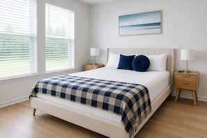 A bedroom with a bed, two bedside tables, a nightstand, a window with blinds, and a wall-mounted picture. - Modern Apt I Prime Location & Workspace (Sherman)