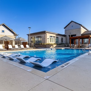 A swimming pool with lounge chairs and a building with large windows. - Modern Apt I Prime Location & Workspace (Sherman)