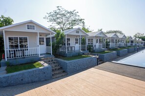 A row of white cabins with stone steps and a wooden deck.