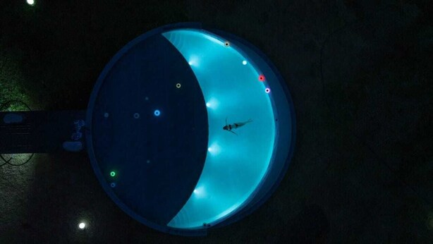 A circular structure with a reflective surface, possibly a pool or a fountain, with a single fish visible inside. - Anchaviyo Resort (Vada)