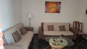 Ett vardagsrum med en soffa, ett soffbord och en lampa.