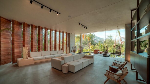 A modern living room with a long white sofa, a small coffee table, and wicker chairs. - Luxury 3BR Oasis | River & Ocean Views 3BD Condo for rent in El Caloso, Puerto v (Puerto Vallarta)