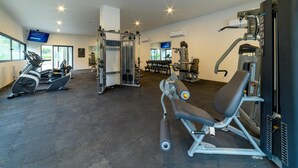 A gym with cardio machines, weightlifting equipment, and a television screen. - Luxury 3BR Oasis | River & Ocean Views 3BD Condo for rent in El Caloso, Puerto v (Puerto Vallarta)