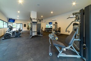 A gym with cardio machines, weightlifting equipment, and a television screen. - Luxury 3BR Oasis | River & Ocean Views 3BD Condo for rent in El Caloso, Puerto v (Puerto Vallarta)