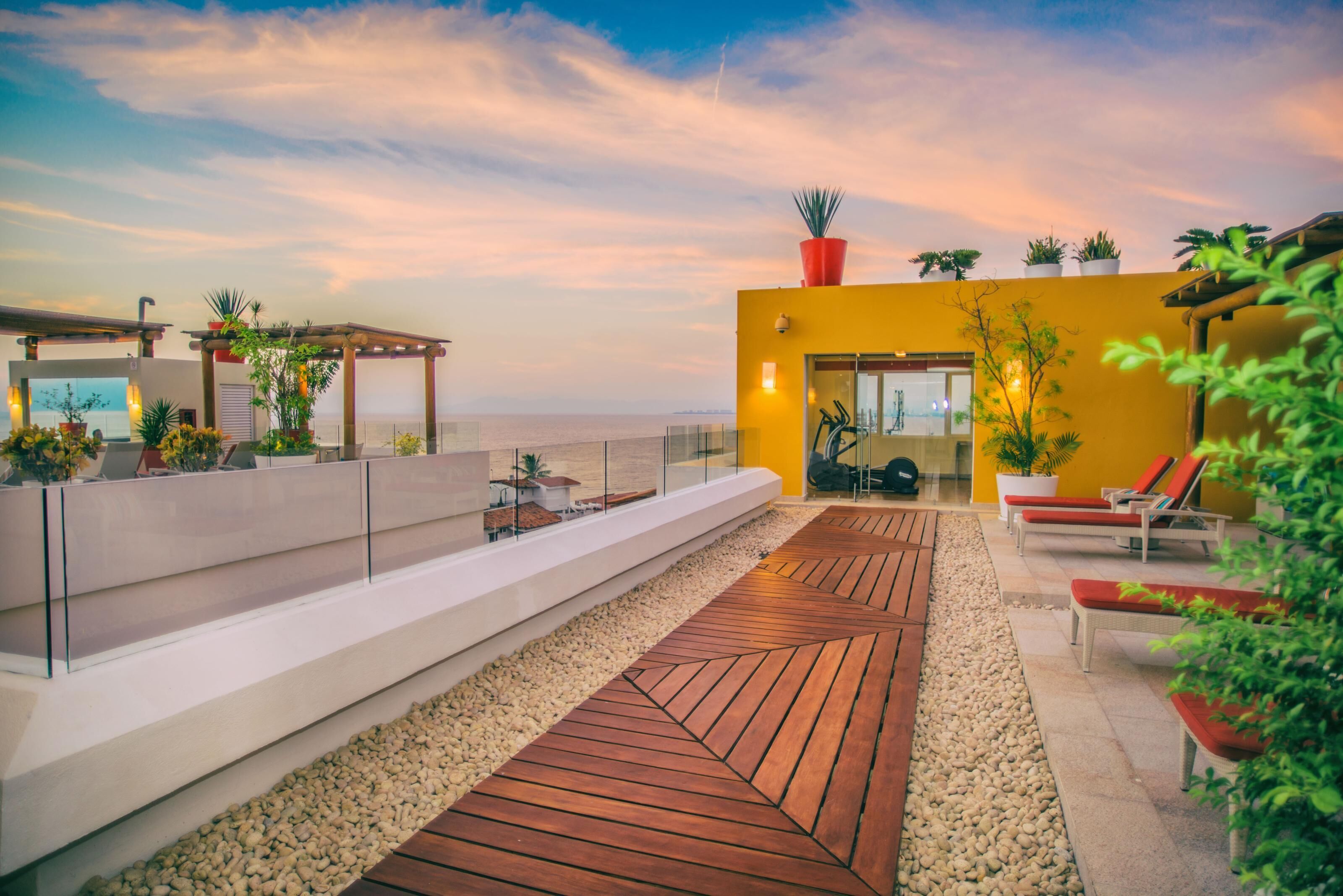 Eine Dachterrasse mit Holzboden, Sitzbereichen und Blumentöpfen.