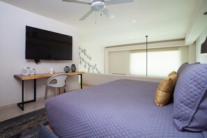 A hotel room with a bed, a desk, a chair, a television, and a window. - Designer Penthouse at V177 | Walk to Beach 1BD Condo for rent in Old Town, Puert (Puerto Vallarta)