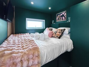 A bedroom with a bed, pillows, a window, and a wall with a poster. - 1 bedroom accommodation in Stranraer (Stranraer)