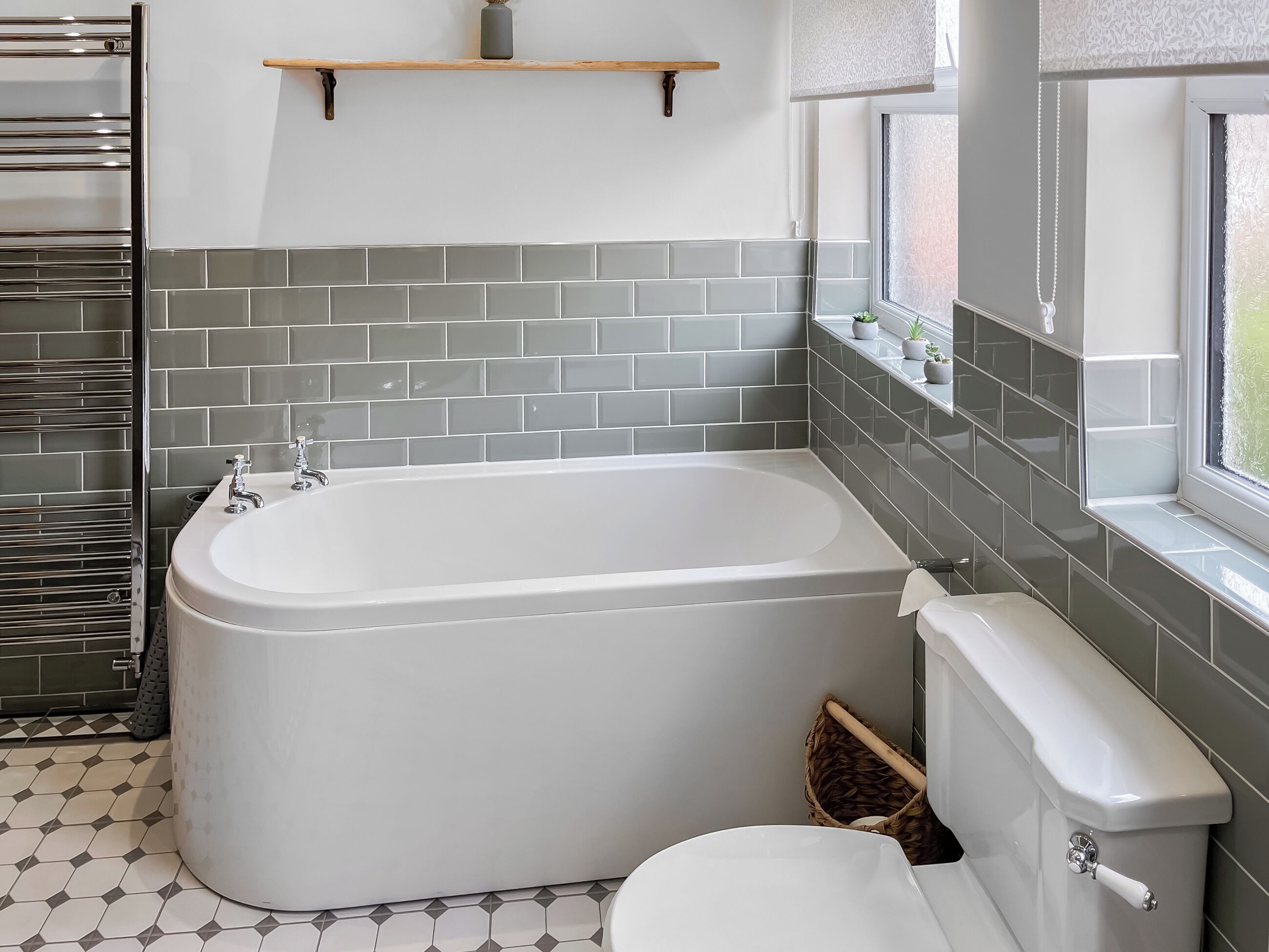 A bathroom with a freestanding bathtub, a toilet, and a window with a view.