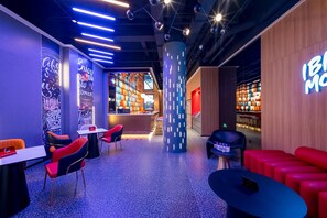 Un espace détente moderne avec des sièges, un comptoir d’accueil et une bibliothèque.