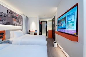 Ein Hotelzimmer mit einem großen Bett, einem Schreibtisch und einem an der Wand montierten Fernseher, der eine Speisekarte zeigt.