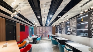 A modern restaurant with high ceilings, perforated panels, and motivational quotes on the walls.