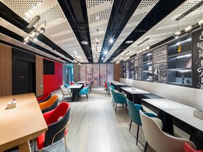 Un restaurant moderne avec de hauts plafonds, des panneaux perforés et des citations inspirantes affichées sur les murs.