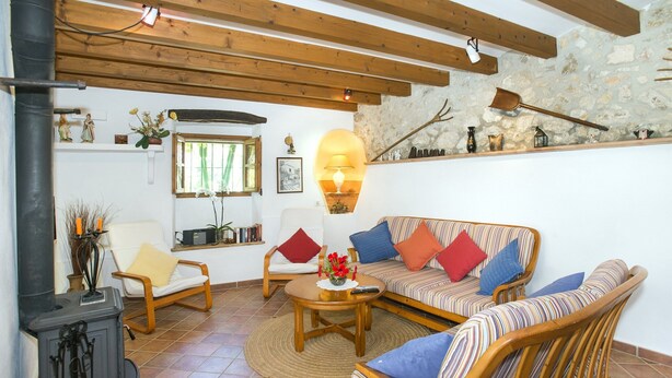 A cozy living room with a fireplace, a sofa, a chair, and a coffee table. - Villa in Pollensa With Mountain Views & Pool (Pollença)