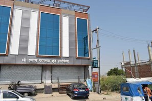 A building with large windows and a closed shutter on the ground floor.