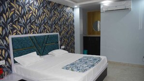 Quarto com cama, ar-condicionado fixado na parede e papel de parede estampado.