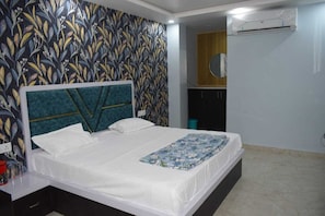 Un dormitorio con cama, aire acondicionado de pared y un papel tapiz estampado.