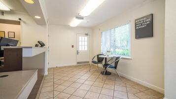 A reception area with a counter, a door, and a window with blinds.