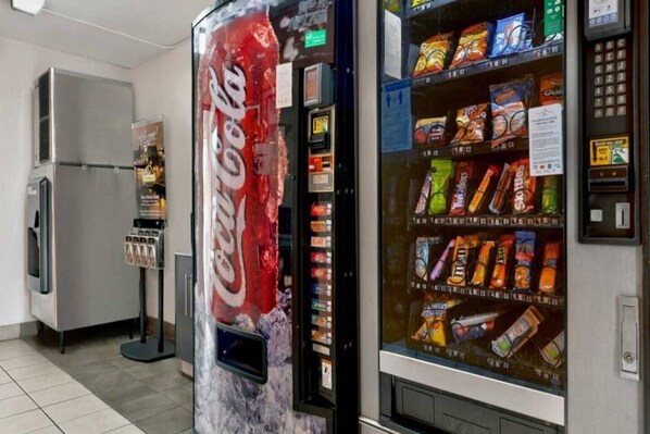 A vending machine with various snacks and a Coca-Cola machine.