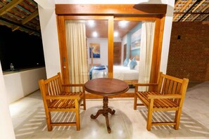 Una mesa y sillas de madera en una habitación con vistas a través de un ventanal.