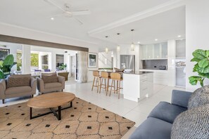 Ein moderner, offener Wohnbereich mit Essplatz, Küche und Blick auf einen Balkon.