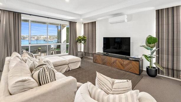 A modern living room with a large TV, comfortable seating, and a view of the sea. - Waterfront Oasis (Minyama)